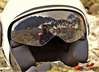 Reflection of young woman photographing on side-view mirror