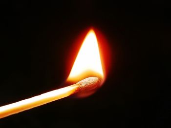 Close-up of lit candle in dark room