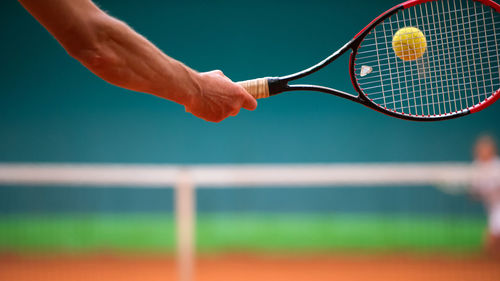 Cropped hand holding tennis racquet