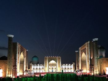 Illuminated mosque against sky at night