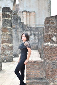 Portrait of young woman standing in old building