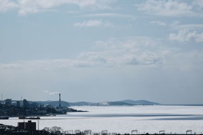 Scenic view of sea by buildings against sky