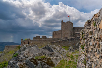 Low angle view of old building against cloudy sky