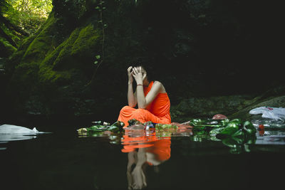 Young woman sitting in lake