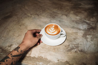 Hand holding coffee cup