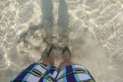 Low section of man standing in water