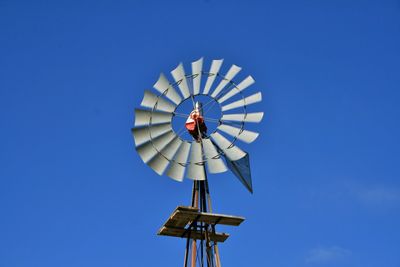 Low angle view of traditional windmill against clear blue sky