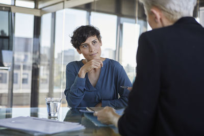 Two businesswomen talking at desk in office