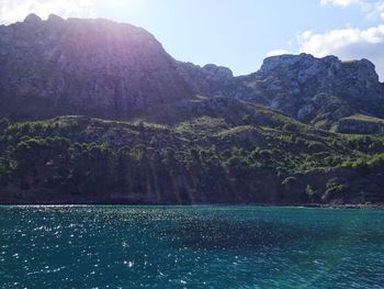 Scenic view of sea and mountains against clear sky