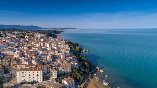 High angle view of townscape by sea against sky