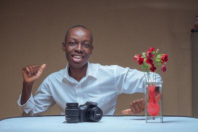 Portrait of smiling man sitting on table