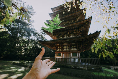 Low section of person by temple against building