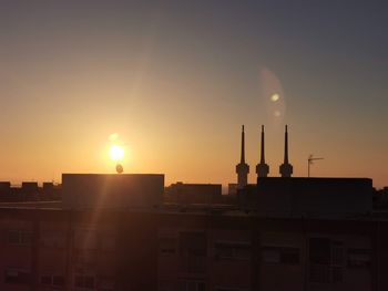 Silhouette buildings against sky during sunset