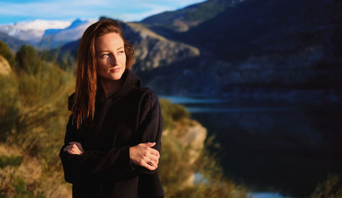 Portrait of beautiful young woman standing on land