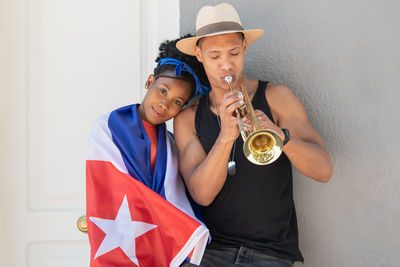 Young couple holding hands against wall
