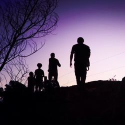 Silhouette of friends against clear sky