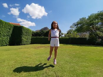 Full length of woman standing on field against sky