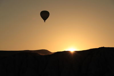 Silhouette hot air balloon against sky during sunset