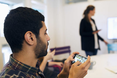 Businessman using smart phone in conference room