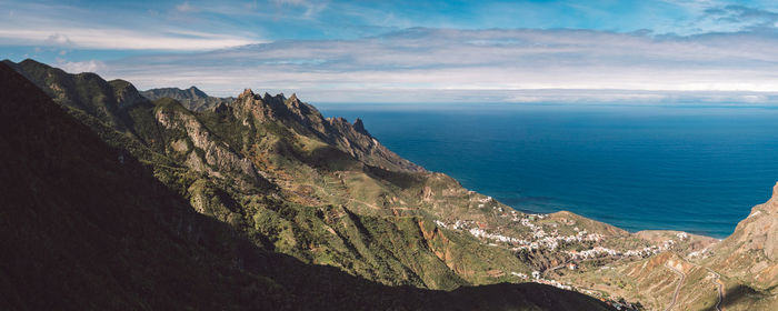 Scenic view of sea and mountains against sky