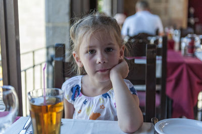 Portrait of cute girl having food in restaurant