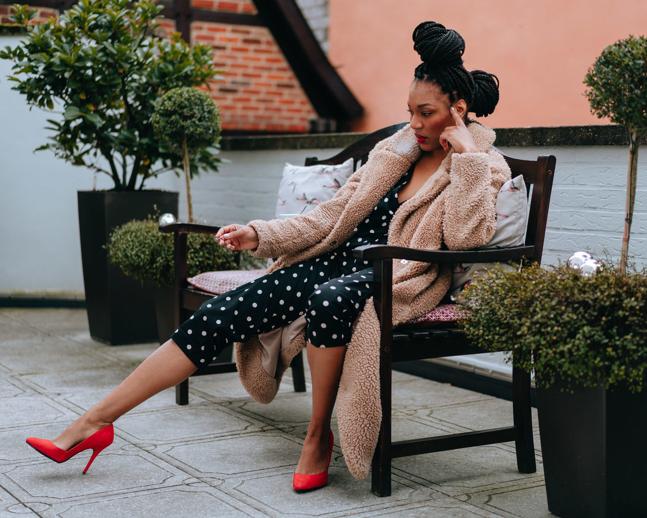 WOMAN LOOKING AT WHILE SITTING ON PLANT