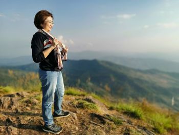 Full length of boy standing on field against sky