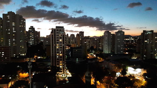 Illuminated cityscape against sky at night