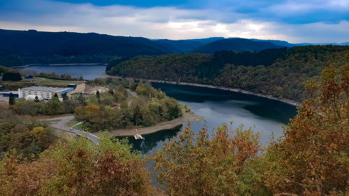 Scenic view of river by mountains against sky