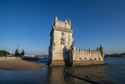 Low angle view of historic building against clear blue sky