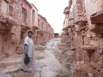 Senior man standing on footpath of ruined castle