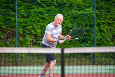 Full length portrait of man playing tennis