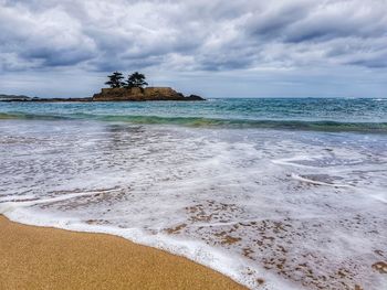 View of beach against cloudy sky