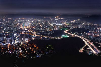 High angle view of illuminated city buildings at night