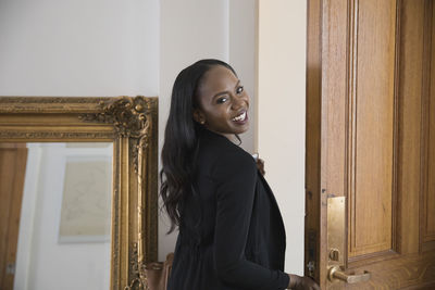 Smiling businesswoman walking through doorway