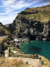 Scenic view of sea by cliff against sky