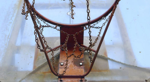 Close-up of rusty chain hanging against wall