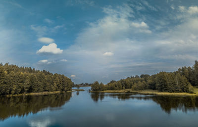 Scenic view of lake by trees against sky