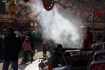 Rear view of people standing on street in city