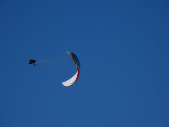 Low angle view of kite flying against clear blue sky