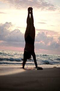 Full length of man on beach against sky during sunset