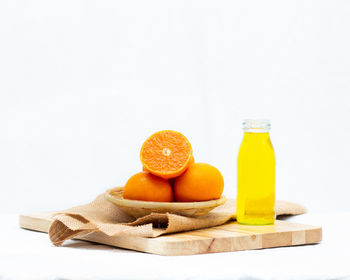 Various fruits on cutting board against white background