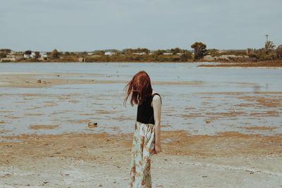 Rear view of woman standing on beach