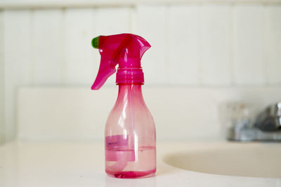 Close-up of pink bottle by sink