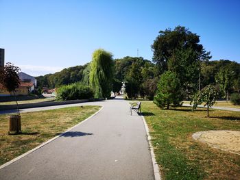 Road amidst trees against clear sky