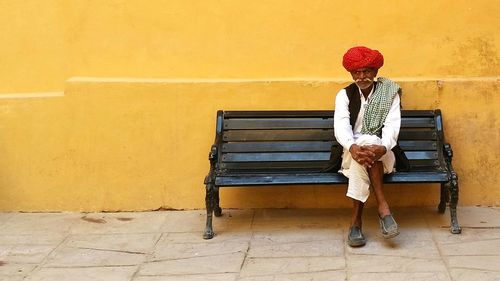 Full length of woman sitting on bench