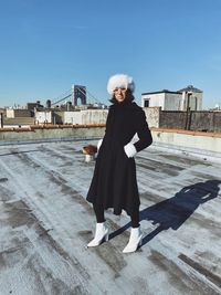 Portrait of woman standing on terrace against sky