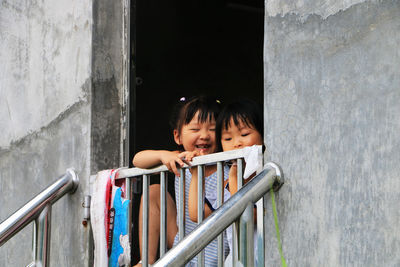 Portrait of a smiling young woman looking through window