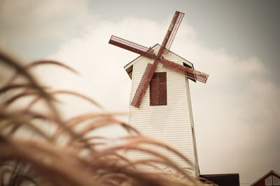 Low angle view of traditional windmill against sky