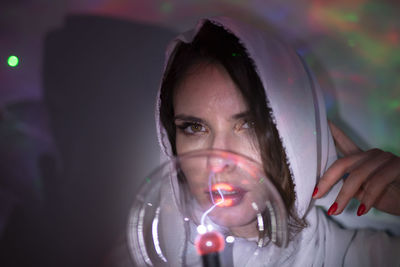 Woman holding crystal ball against wall